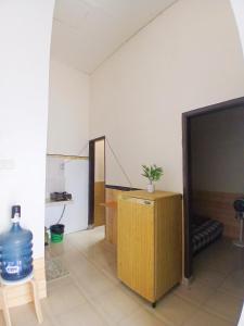 ein Zimmer mit Fernseher und Schreibtisch mit einer Topfpflanze in der Unterkunft Homestay Nyaman di Pusat Kota in Blimbing