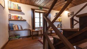 a staircase in a room with bookshelves and a window at Archontiko Filippidi in Mileai