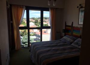 a bedroom with a bed and a large window at PUNTA MOGOTES Hermosa vista almar in Mar del Plata +49 photos