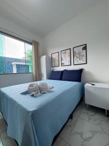 Un dormitorio con una cama azul con toallas. en pousada tudo a ver, en Salinas da Margarida