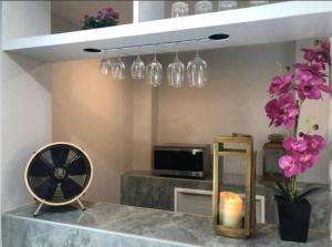 a room with a table with a fan and flowers at 51 Suanplu Residence in Bangkok