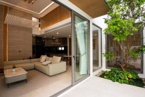 ein Wohnzimmer mit Sofa und Tisch in der Unterkunft Mila Luxury 3BR Villa, Private 4x10m Pool in Ban Saiyuan (1)