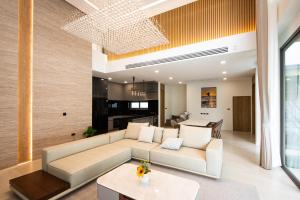 ein Wohnzimmer mit Sofa und Tisch in der Unterkunft Mila Luxury 3BR Villa, Private 4x10m Pool in Ban Saiyuan (1)