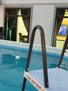 einen Pool mit einem Stuhl davor in der Unterkunft Muar Bakri Good Day Corner Pool Villa Family Friends Gathering Party in Muar