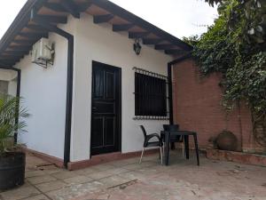 a chair and a table in front of a house at Ángela María in Caacupé