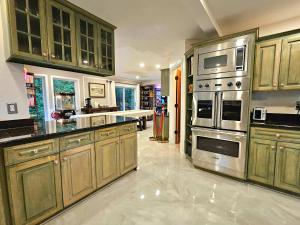 eine Küche mit Holzschränken und Geräten aus Edelstahl in der Unterkunft Mountain View Estate Forest Hot Tub Full Arcade in Snohomish