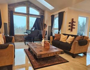ein Wohnzimmer mit einem Sofa, einem Tisch und einem Klavier in der Unterkunft Mountain View Estate Forest Hot Tub Full Arcade in Snohomish
