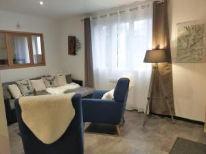 ein Wohnzimmer mit einem Sofa und einem blauen Stuhl in der Unterkunft L'R du Roc : Appartement Duplex 4* avec Terrasse et Garage - FR-1-858-7 in La Bourboule