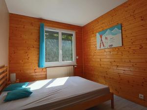 ein Schlafzimmer mit einem Bett und einem Fenster in der Unterkunft Charmante maison familiale à La Bourboule - FR-1-858-15 in La Bourboule