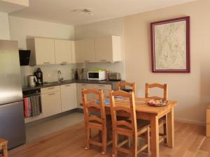 une cuisine avec une table et des chaises et un micro-ondes dans l'établissement Chalet Montagne avec Terrasse et Parking - FR-1-858-29, à Mont-Dore 11 autres photos