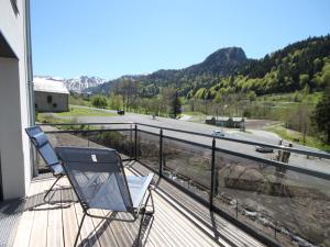 une chaise sur un balcon avec vue sur une route dans l'établissement Chalet Montagne avec Terrasse et Parking - FR-1-858-29, à Mont-Dore