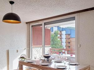 une table de salle à manger avec vue sur une fenêtre dans l'établissement Studio confortable pour 6, au pied des pistes, Sud - FR-1-811-46, à Les Deux Alpes