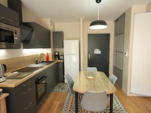 une petite cuisine avec une table et des chaises en bois dans l'établissement Charmant appartement scandinave avec parking au Mont-Dore - FR-1-858-1, à Mont-Dore