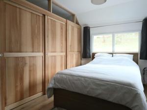 une chambre avec un grand lit et une fenêtre dans l'établissement Maison neuve 4* pour 6 personnes au Mont Dore avec terrasse - FR-1-858-5, à Mont-Dore