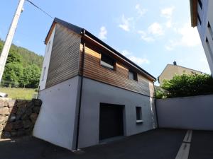 un grand bâtiment blanc avec un toit marron dans l'établissement Maison neuve 4* pour 6 personnes au Mont Dore avec terrasse - FR-1-858-5, à Mont-Dore
