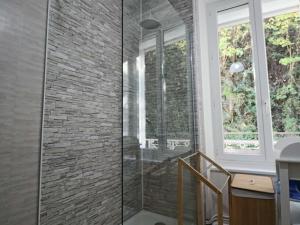 eine Glasdusche im Bad mit Ziegelwand in der Unterkunft Grande maison jusqu'à 8 personnes à La Bourboule - FR-1-858-6 in La Bourboule + 28 Fotos