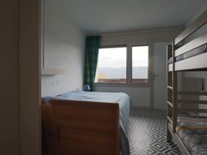 a bedroom with a bed and a window at Charmant Duplex 4 Pers. avec Parking Privé à Murat-le-Quaire - FR-1-858-9 in Murat-le-Quaire