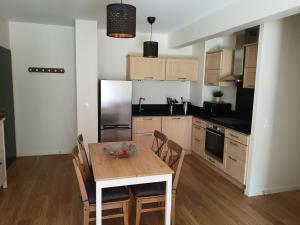 une cuisine avec une table avec des chaises et un réfrigérateur dans l'établissement Appartement 2 pièces avec jardin et parking, proche Thermes et ski - FR-1-858-18, à Mont-Dore