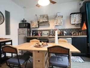 eine Küche mit einem Holztisch und Stühlen in der Unterkunft Appartement 3* pour 6 pers, calme, proche thermes - FR-1-858-30 in La Bourboule