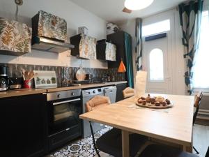 eine Küche mit einem Holztisch und einem Holztisch sidx sidx sidx in der Unterkunft Appartement 3* pour 6 pers, calme, proche thermes - FR-1-858-30 in La Bourboule + 4 Fotos