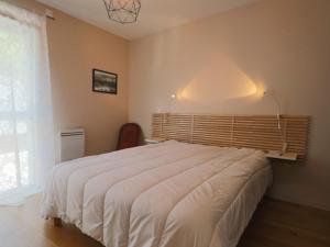 une chambre avec un lit blanc et une fenêtre dans l'établissement Appartement chaleureux 6 pers avec terrasse au Mont-Dore - FR-1-858-31, à Mont-Dore