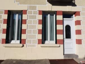 drei Fenster auf der Seite eines Backsteingebäudes in der Unterkunft Appartement 3* pour 6 pers, calme, proche thermes - FR-1-858-30 in La Bourboule