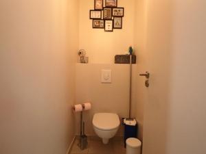 une petite salle de bain avec toilettes et des tableaux au mur dans l'établissement Appartement chaleureux 6 pers avec terrasse au Mont-Dore - FR-1-858-31, à Mont-Dore 12 autres photos