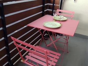 une table rose avec deux chaises et des verres à vin dessus dans l'établissement Studio 4 pers au cœur de Super Besse, proche pistes - FR-1-814-171, à Super-Besse 18 autres photos