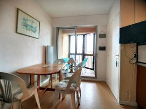 ein Esszimmer mit einem Holztisch und Stühlen in der Unterkunft Appartement T2 à Vieux-Boucau, 4 pers, parking inclus - FR-1-857-14 in Vieux-Boucau-les-Bains + 1 Foto