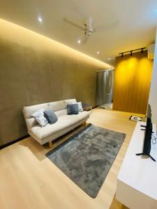 ein Wohnzimmer mit einer weißen Couch und einem Teppich in der Unterkunft Majestic Manhattan Suites ITCC in Penampang