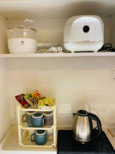 ein Küchenregal mit einer Teekanne und einem Mixer in der Unterkunft Majestic Manhattan Suites ITCC in Penampang + 3 Fotos