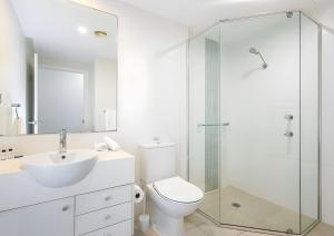 a bathroom with a toilet and a sink and a shower at Studio Lagoon Apartment in Salamander Bay