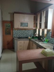 a kitchen with white cabinets and a counter top at Villa Hayoo ayem in Sukowati