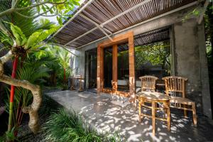 a patio with chairs and a table and a window at Dedeane Hotel & Yoga Retreat in Ubud