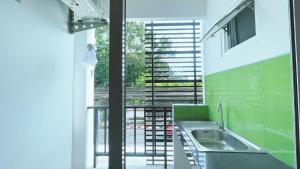 a kitchen with a sink and a large window at The Nap House Phuket Town in Phuket Town