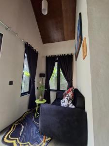 a living room with a black couch and a table at Mini Village in Batukaras
