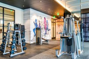 een fitnessruimte met verschillende loopbanden en een muurschildering bij The Stay 2 - Tysons Corner in McLean