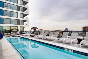 une piscine sur le toit d'un immeuble avec des chaises longues dans l'établissement The Stay 2 - Tysons Corner, à McLean