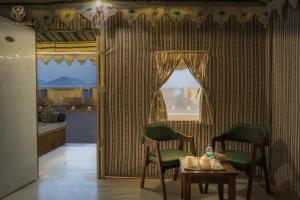 a room with two chairs and a table and a window at Jaisan Heritage Desert Camp in Jaisalmer