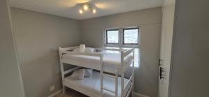 a small room with white bunk beds in it at 59 De Valle, Diaz Beach in Mossel Bay +23 photos