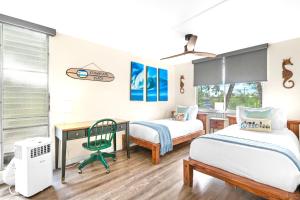 Un dormitorio con dos camas y un escritorio. en Kalama Terrace 2BR with Pool, BBQ, AC & Walk to the Beach, en Kihei