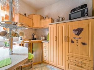 a kitchen with wooden cabinets and a counter top at Ferienwohnung in der Nähe des Brockengipfels in Ilsenburg