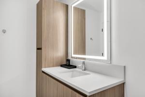 une salle de bains avec un lavabo blanc et un miroir dans l'établissement The Stay 2 - Tysons Corner, à McLean 97 autres photos