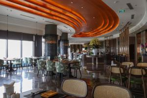 a restaurant with tables and chairs and a bar at Nesta Celia Da Nang Hotel in Da Nang