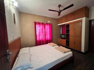 a bedroom with a large bed with a pink window at Spacious 3BHK Family Home in Bengaluru