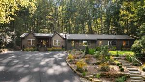 a house in the woods with a driveway at Dahlia House, 3 BDRM Walk To Town in Highlands