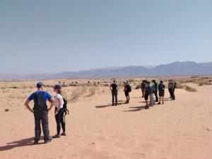 Un groupe de personnes marchant dans le désert dans l'établissement Halfway motel, à An Namatah