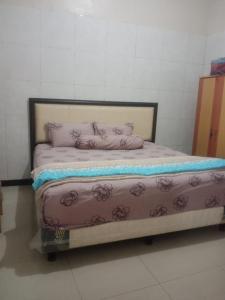 a bed with pink sheets and pillows in a room at Villa Hayoo ayem in Sukowati