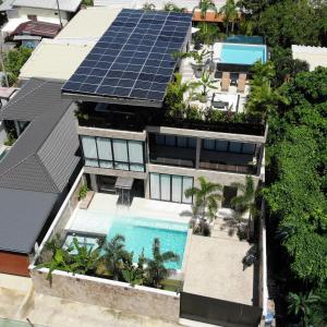 ラワイビーチにあるVilla Astra Rawai Phuketの屋根にソーラーパネルが設置された家の航空写真