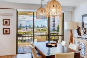 a dining room with a table and chairs and a balcony at The Meriton Apartments on Main Beach in Gold Coast